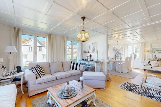 living area with coffered ceiling, healthy amount of natural light, and light wood finished floors