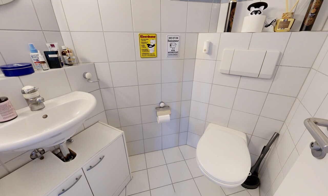 salle de bains avec tile wall, toilette, inside community, évier, et tile floor