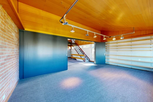 pièce vide avec mur en brique, brick wall, escaliers, moquette, et carpet