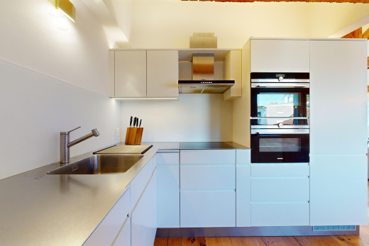 küche mit doppelter ofen, arbeitsplatten, parkettboden, waschbecken, und dunstabzugshaube