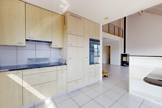 cuisine avec armoires marron clair, light brown cabinets, light floor, dark countertops, et inside property