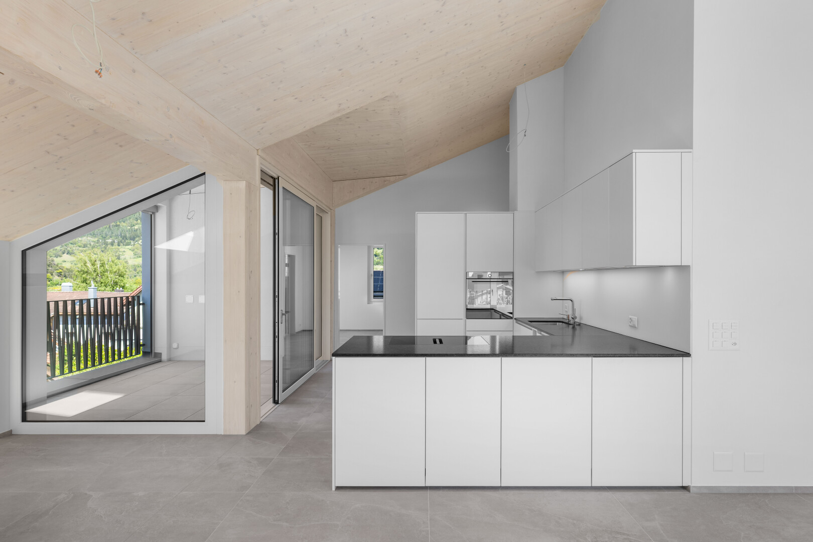cuisine avec péninsule de cuisine, kitchen peninsula, four, sol en béton, et concrete floor