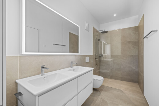 salle de bains avec double vasque, salle de bain complète, douche, inside property, et light floor