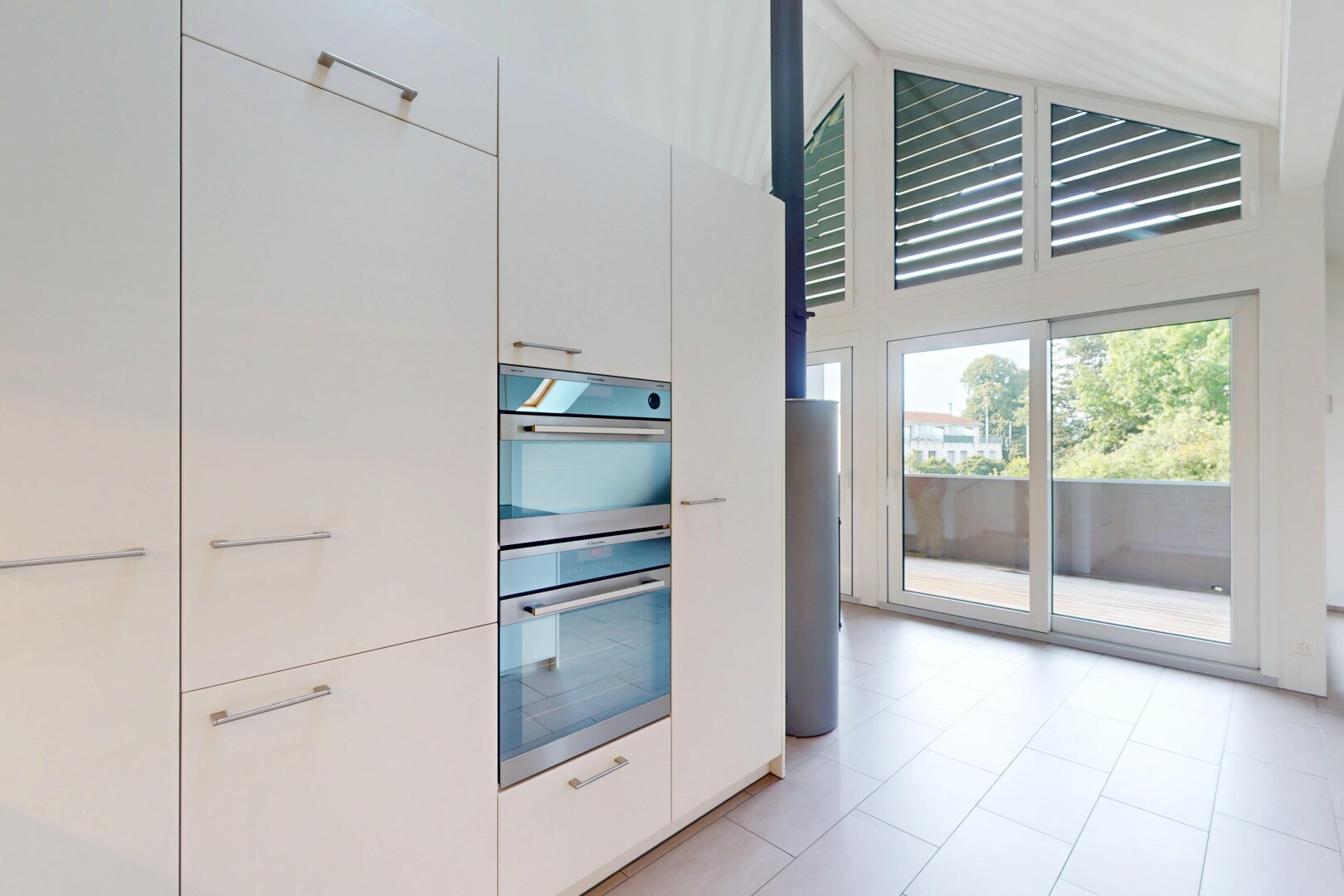 cuisine avec four double, lumière naturelle, natural light, plafond haut, et high ceiling
