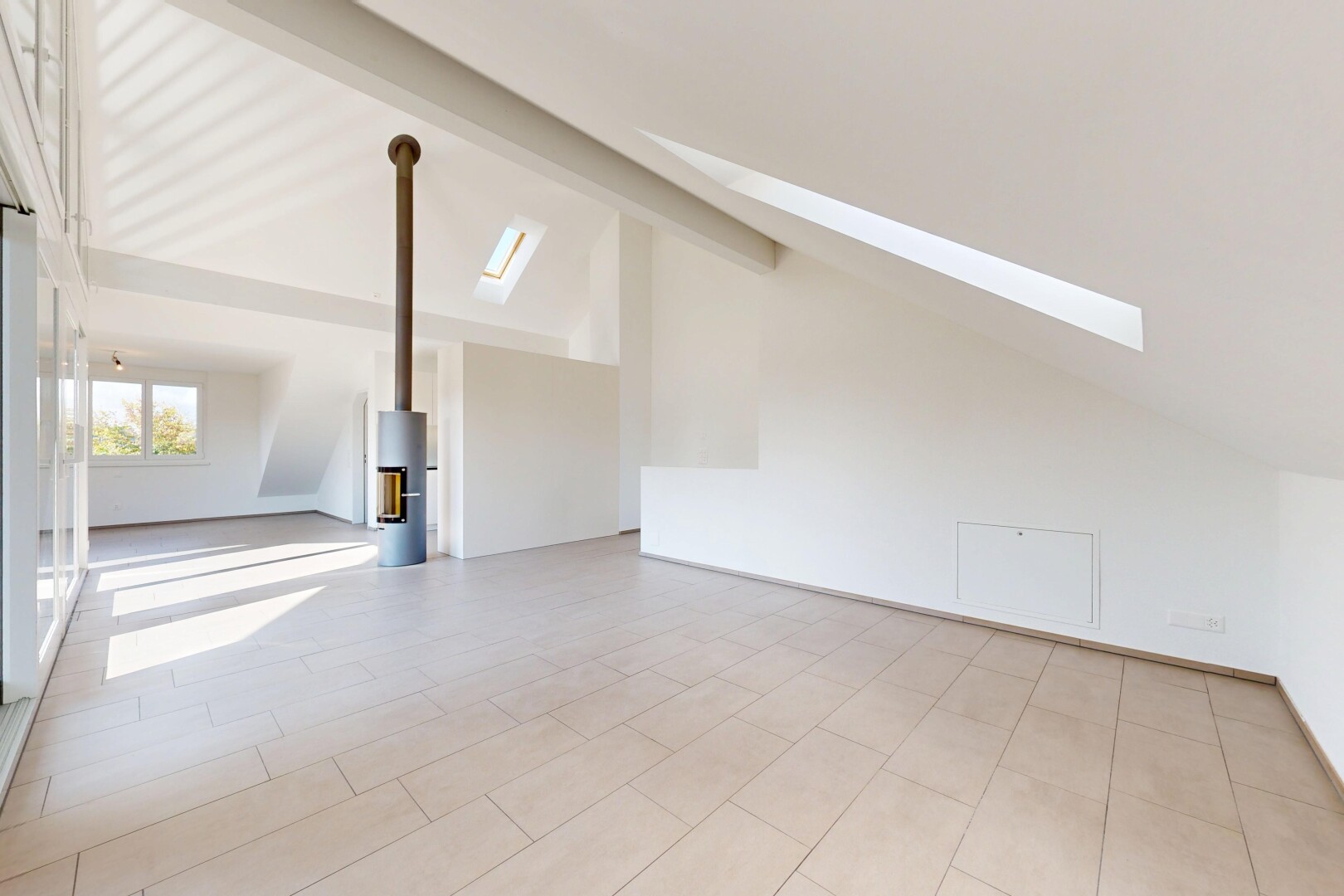 pièce vide avec vaulted ceiling, plafond voûté, beamed ceiling, plafond à poutres, et puits de lumière