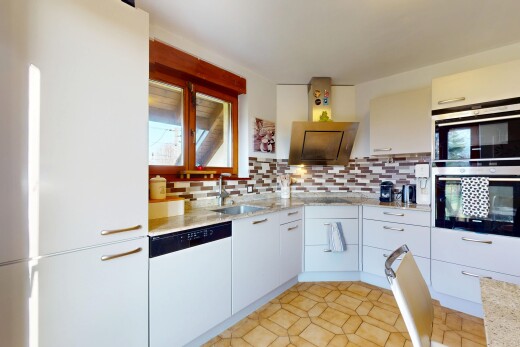 küche mit doppel backofen, küchenrückwand beim herd, weiße schränke, geschirrspülmaschine, und waschbecken