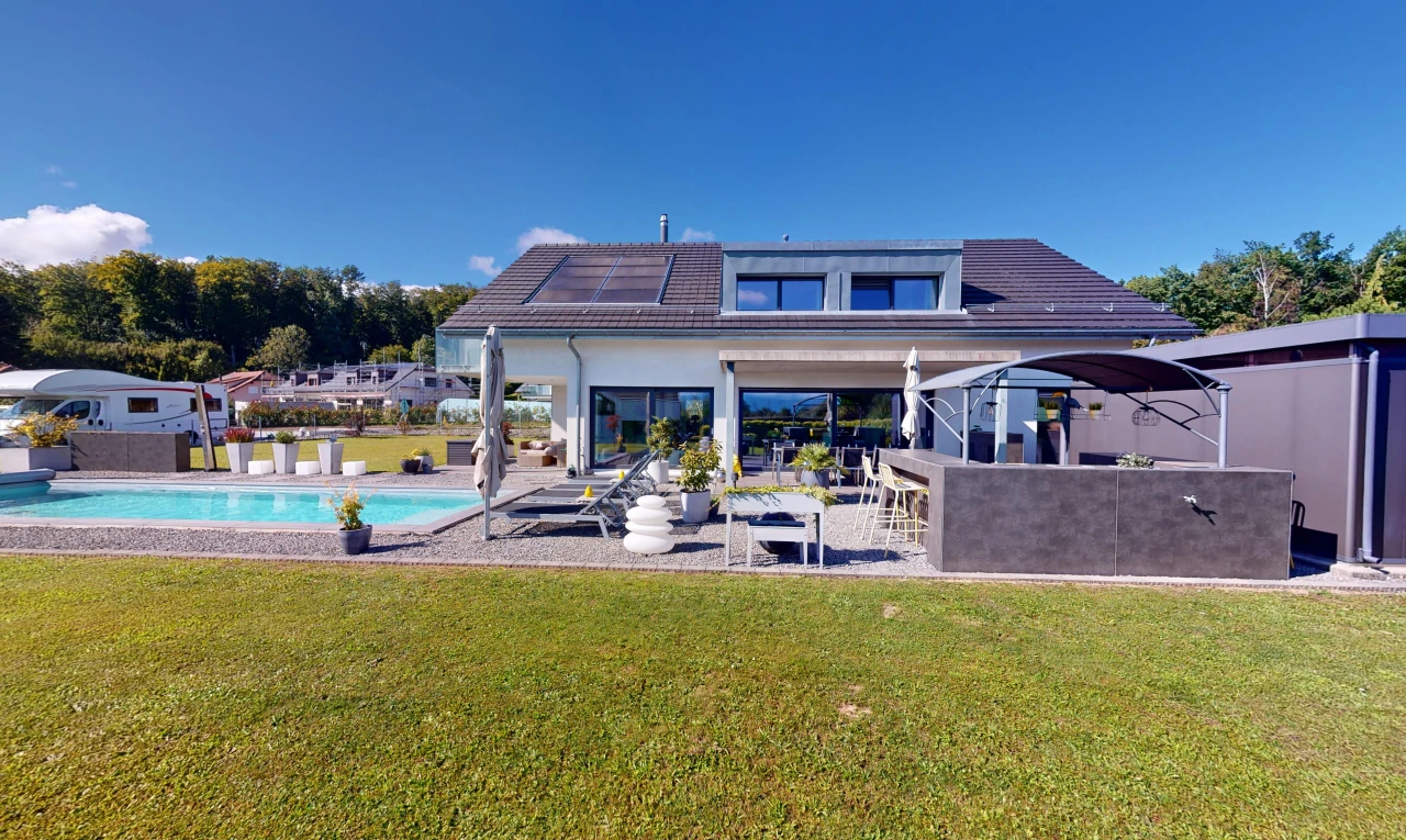 façade avec panneaux solaires, patio, piscine, et pelouse