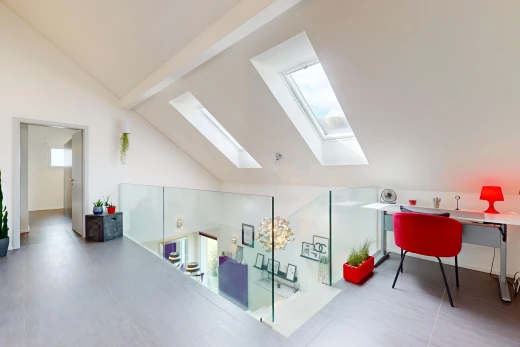 espace intérieur avec lumière naturelle, lucarne, plafond voûté, et haut plafond