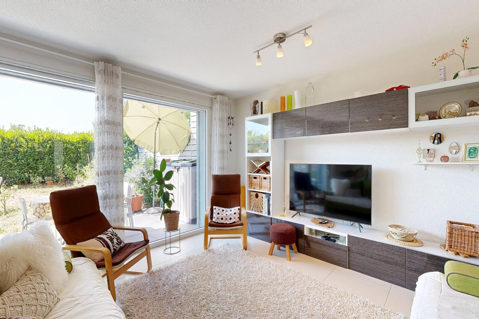 salon avec éclairage sur rail, télévision, cloison sèche, drywall, et inside property
