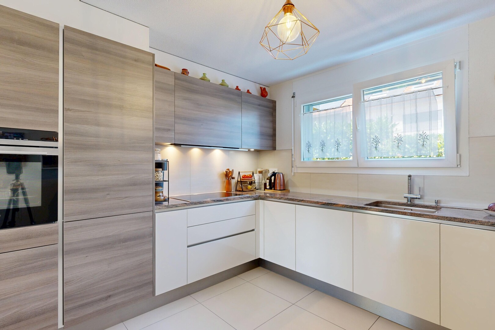 cuisine avec light floor, flat panel cabinets, armoires à panneau plat, évier, et four