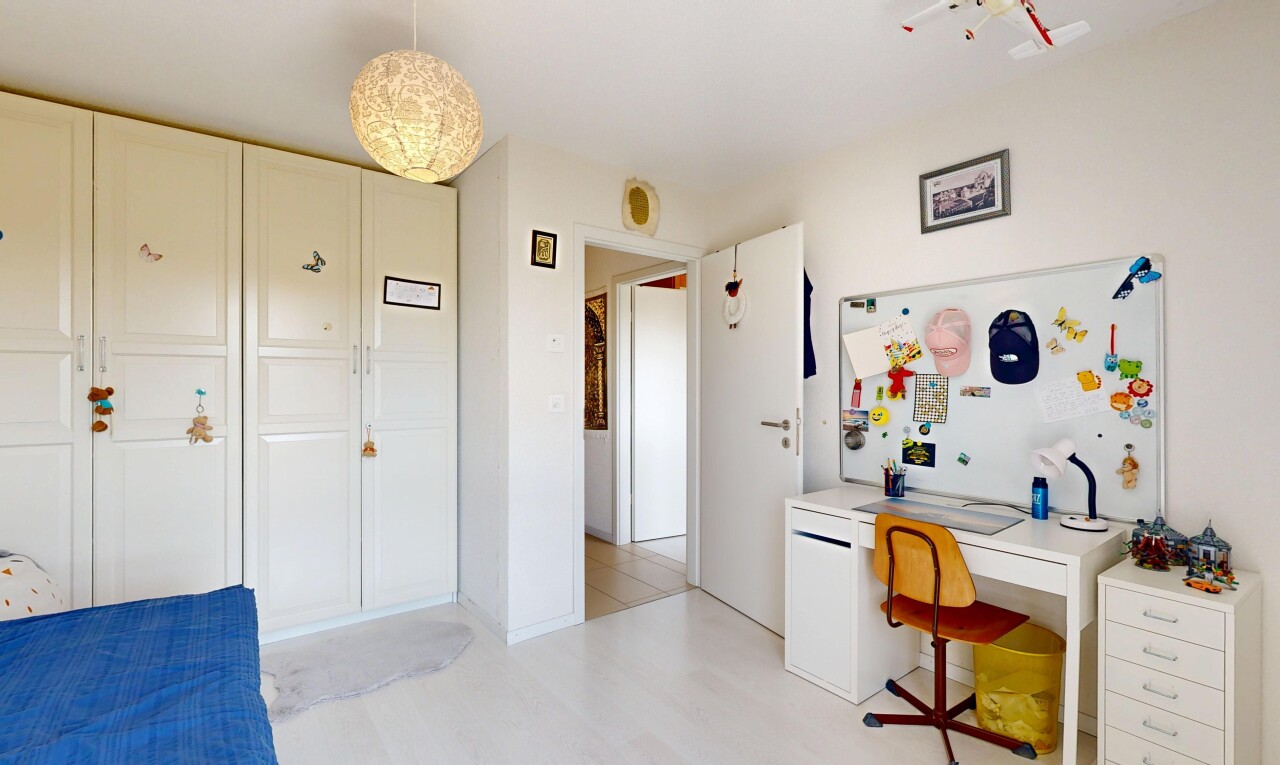 chambre avec drywall, cloison sèche, espace bureau, placard, et éclairage suspendu