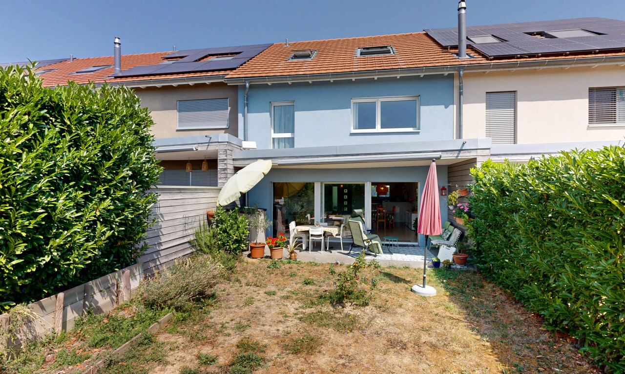 façade avec terrasse, property visible, panneaux solaires, bardage en stuc, et day time