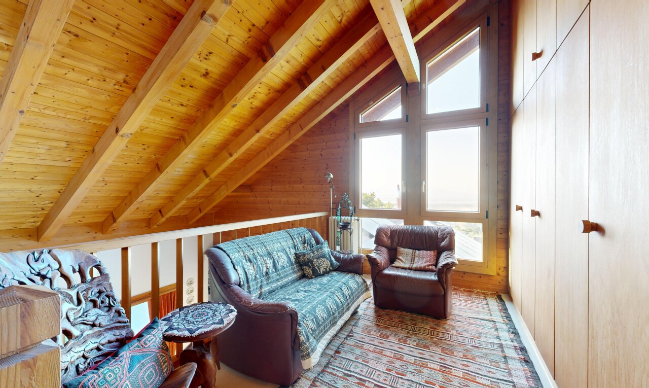 salon avec mezzanine, plafond à poutres, beamed ceiling, plafond voûté, et vaulted ceiling