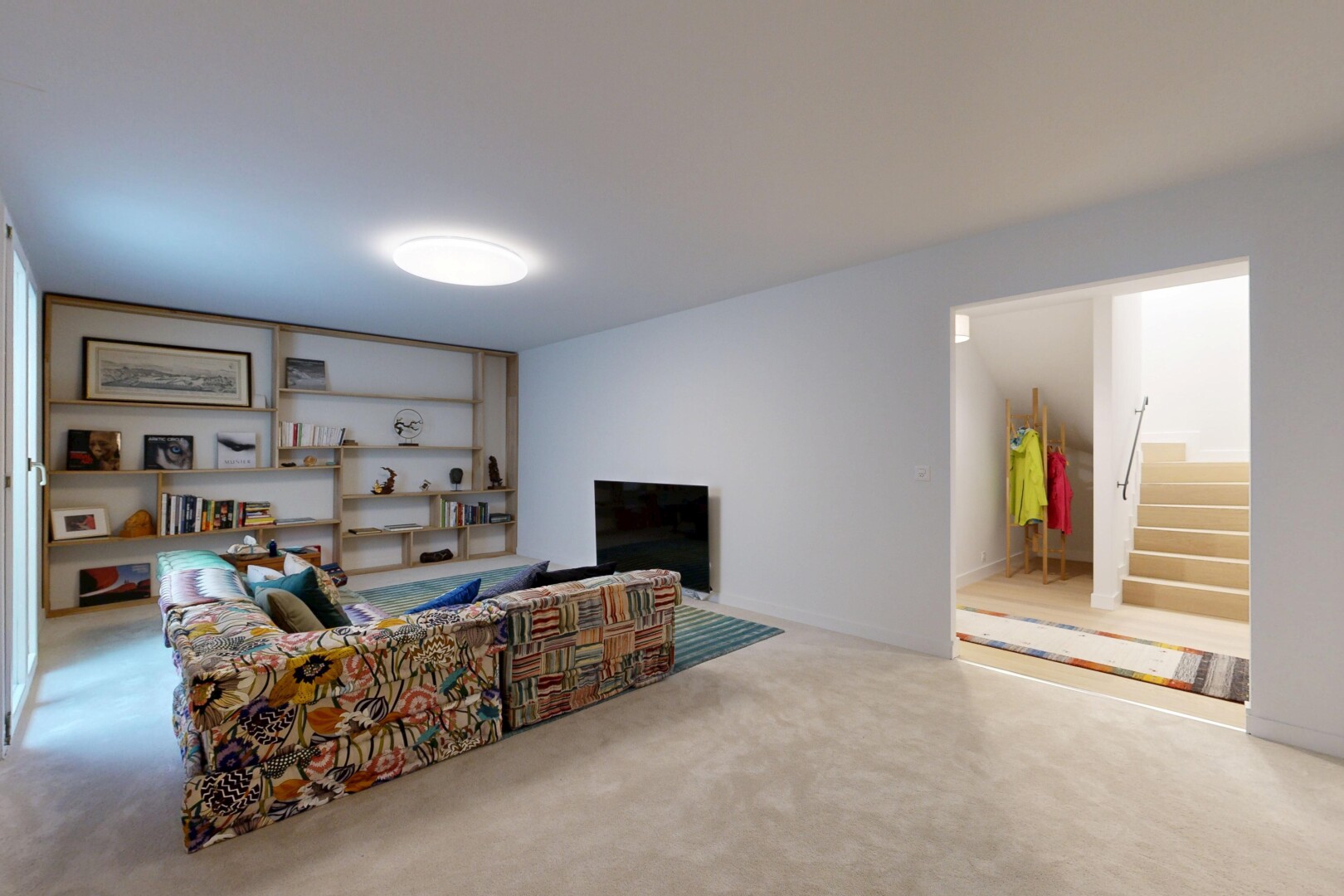 carpeted living room with stairs