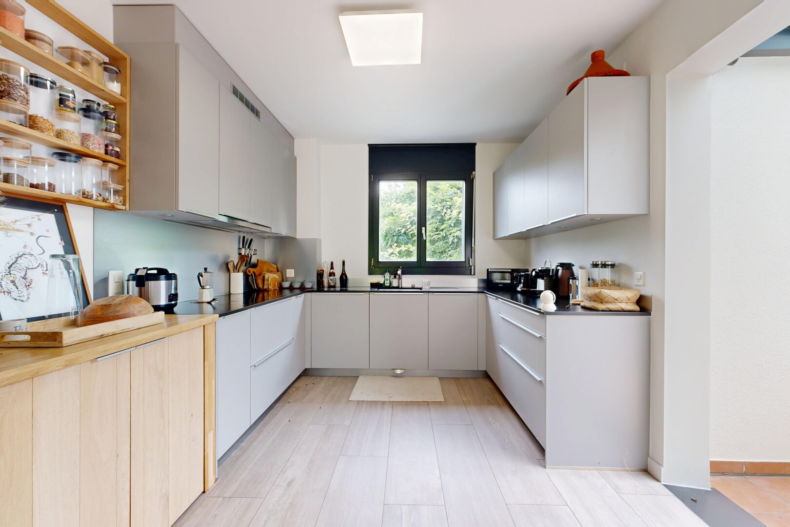 kitchen with dual tone cabinetry, modern cabinets, dark countertops, and open shelves