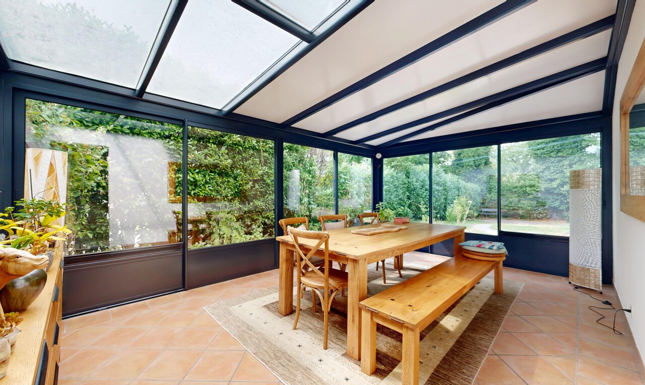 dining space with light tile patterned floors and vaulted ceiling