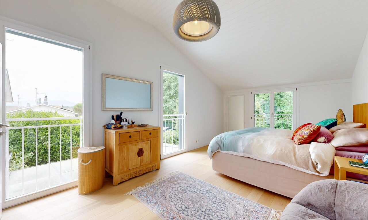room / bedroom featuring access to outside, vaulted ceiling, light wood-style flooring, and decorative light fixtures