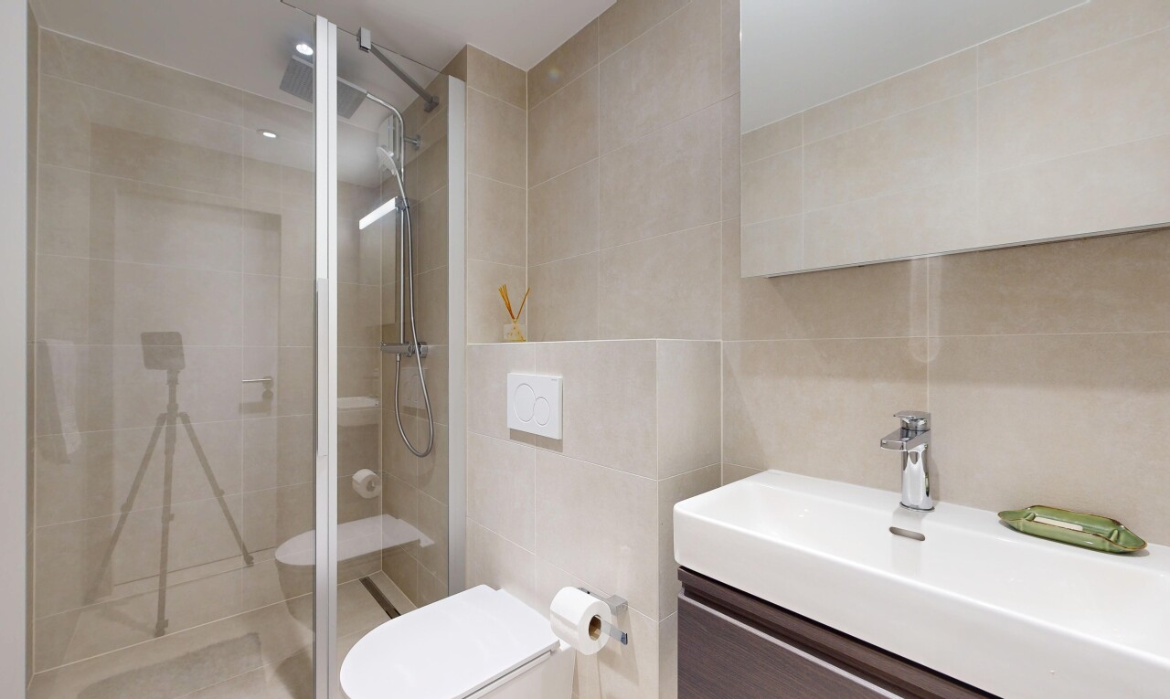 full bath featuring a shower stall, tile walls, and vanity