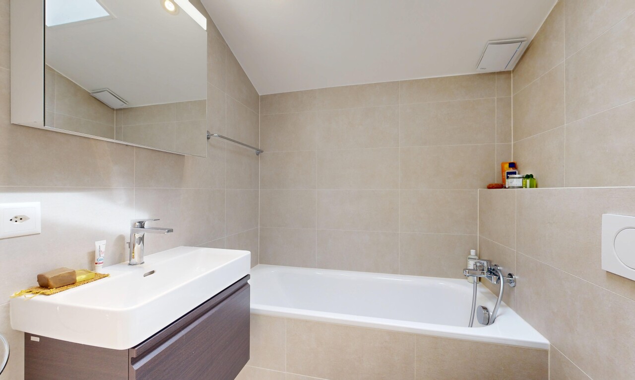 bathroom with vanity, tile walls, and a bath