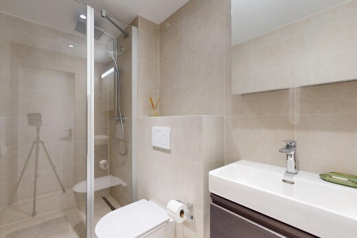 full bath featuring a shower stall, tile walls, and vanity