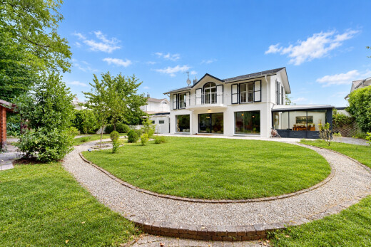 view of home with a lawn and a balcony