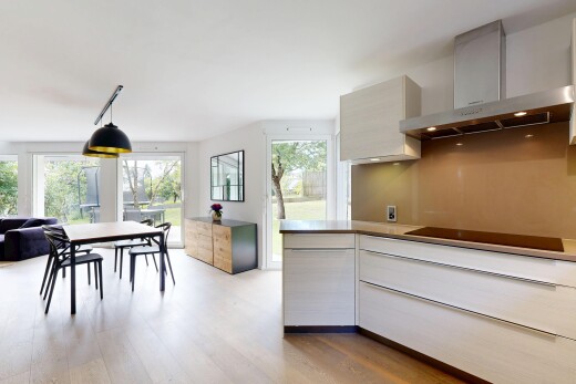 cuisine avec armoires à panneau plat, hotte, inside property, sol en finition bois, et wood finish floor