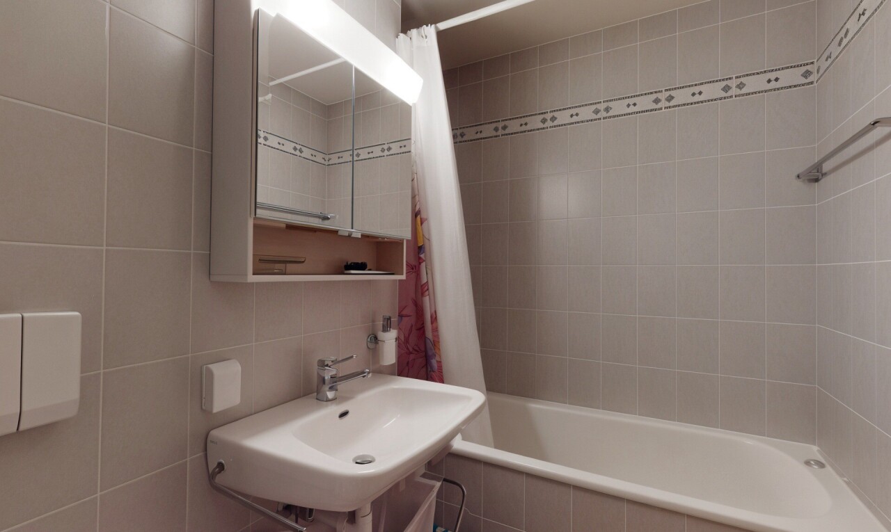 bathroom with tile walls, tiled shower / bath combo, and backsplash