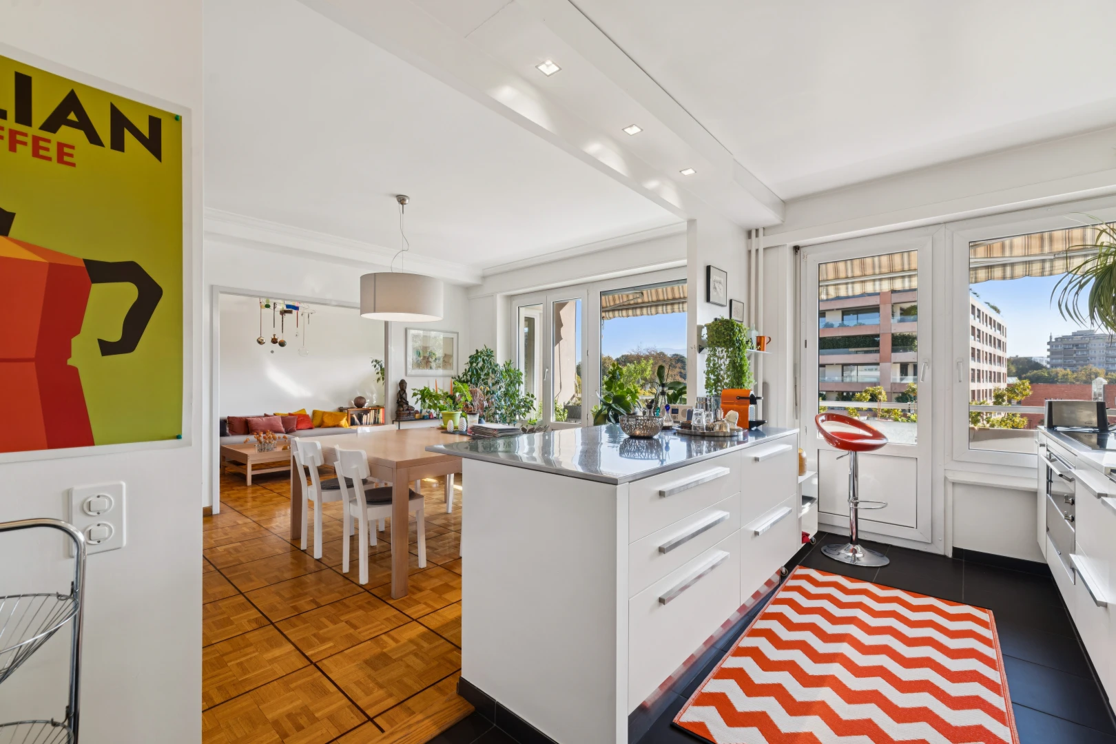 kitchen featuring white cabinets, modern cabinets, access to outside, hanging light fixtures, and parquet floors