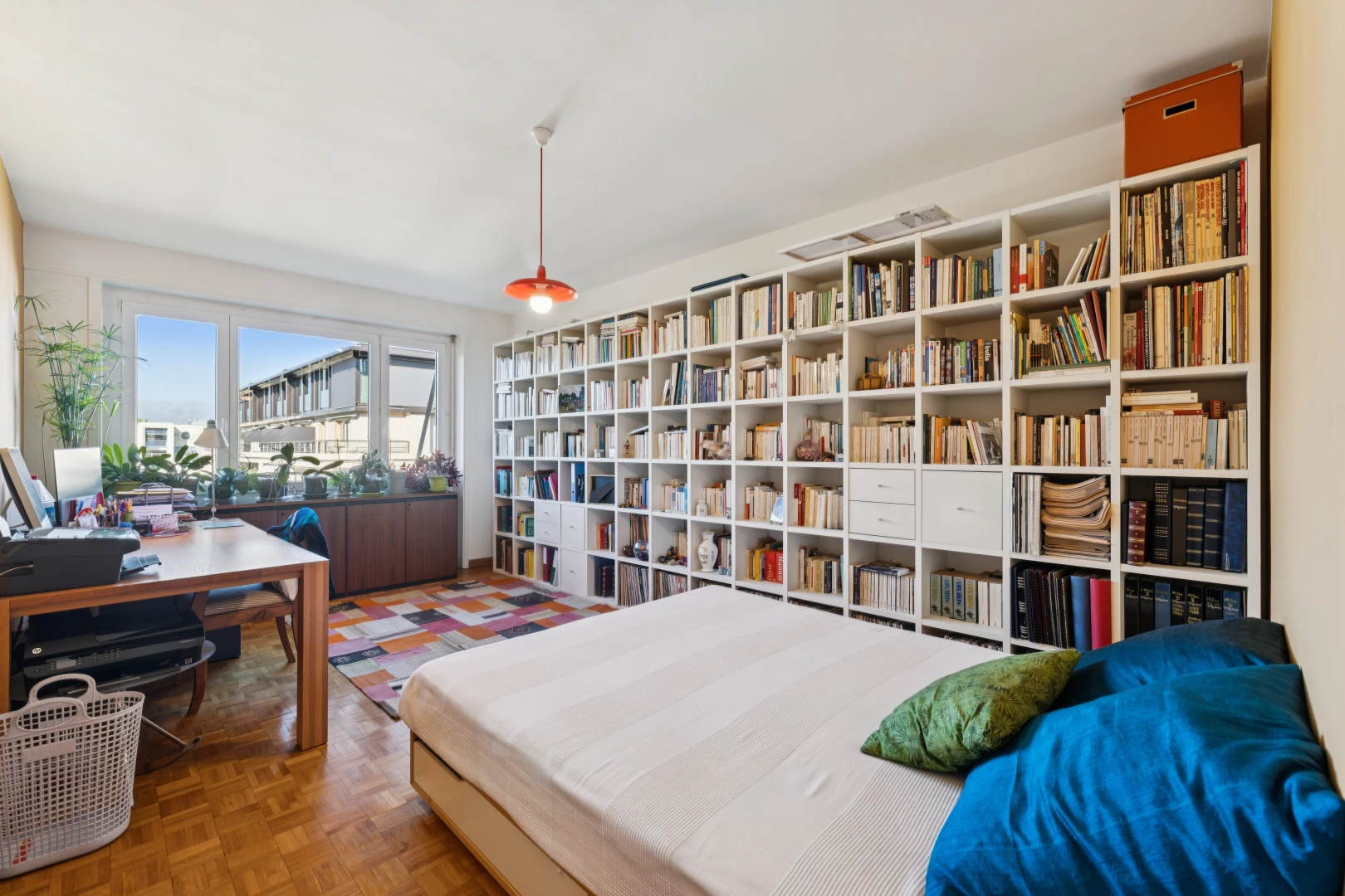 room / bedroom featuring decorative light fixtures, an office area, and parquet floors