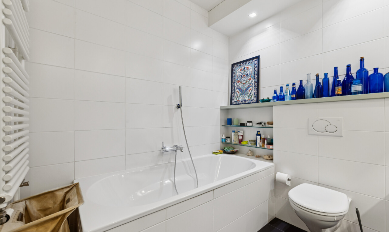 salle de bains avec tile wall, mur en carrelage, radiateur, bain, et salle de bain complète