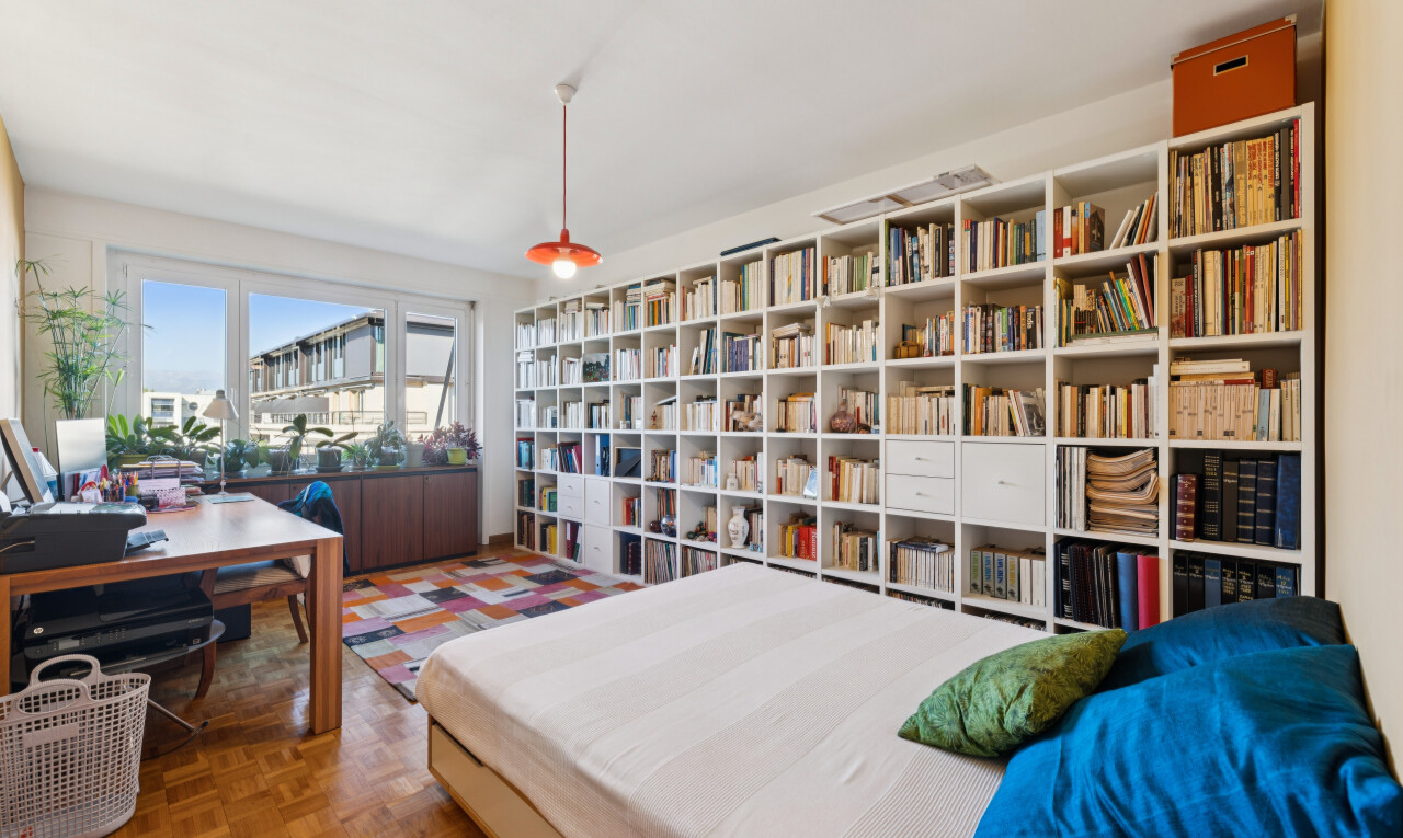 chambre avec éclairage suspendu, espace bureau, inside property, parquet floor, et wood finish floor