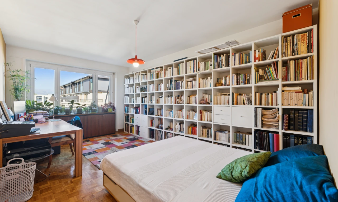 room / bedroom featuring decorative light fixtures, an office area, and parquet floors