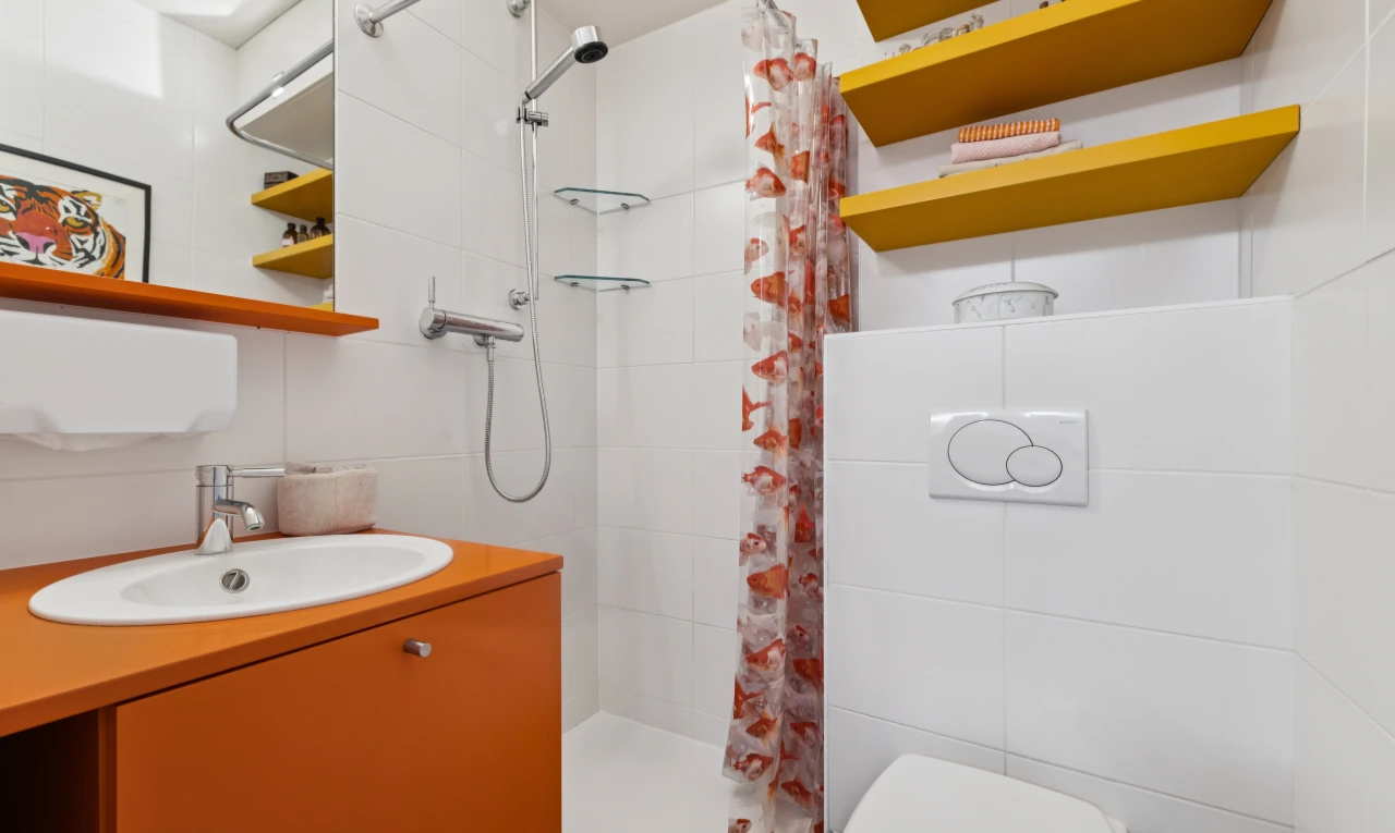 full bath featuring a stall shower, vanity, and tile walls