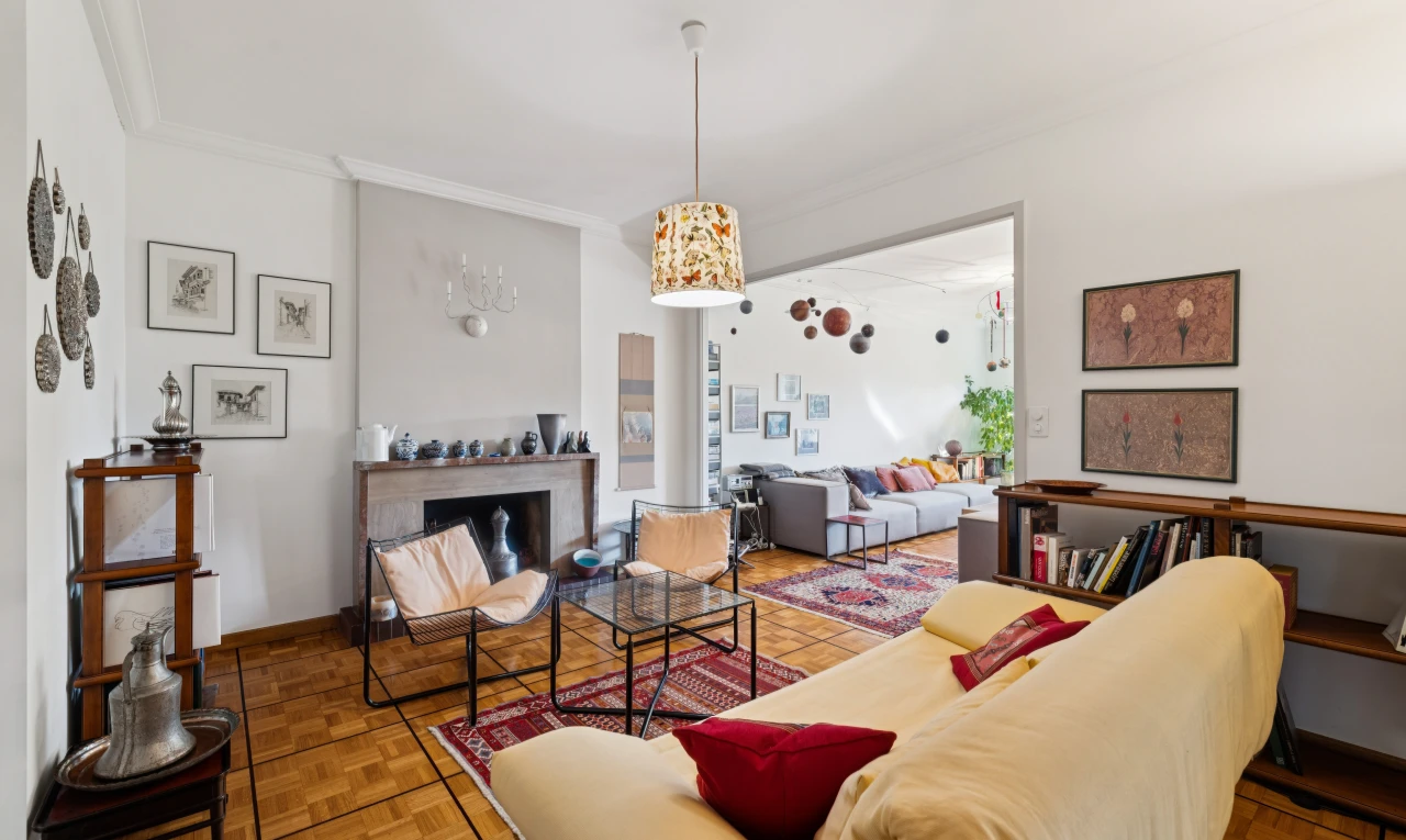 living room with decorative light fixtures, parquet floors, crown molding, and a fireplace