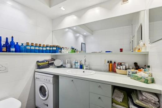 bathroom featuring washer / clothes dryer, vanity, tile walls, and recessed lighting