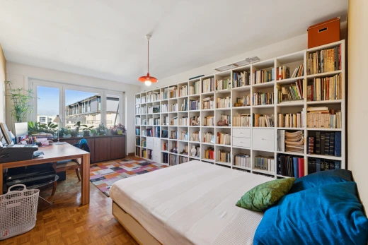 room / bedroom featuring decorative light fixtures, an office area, and parquet floors