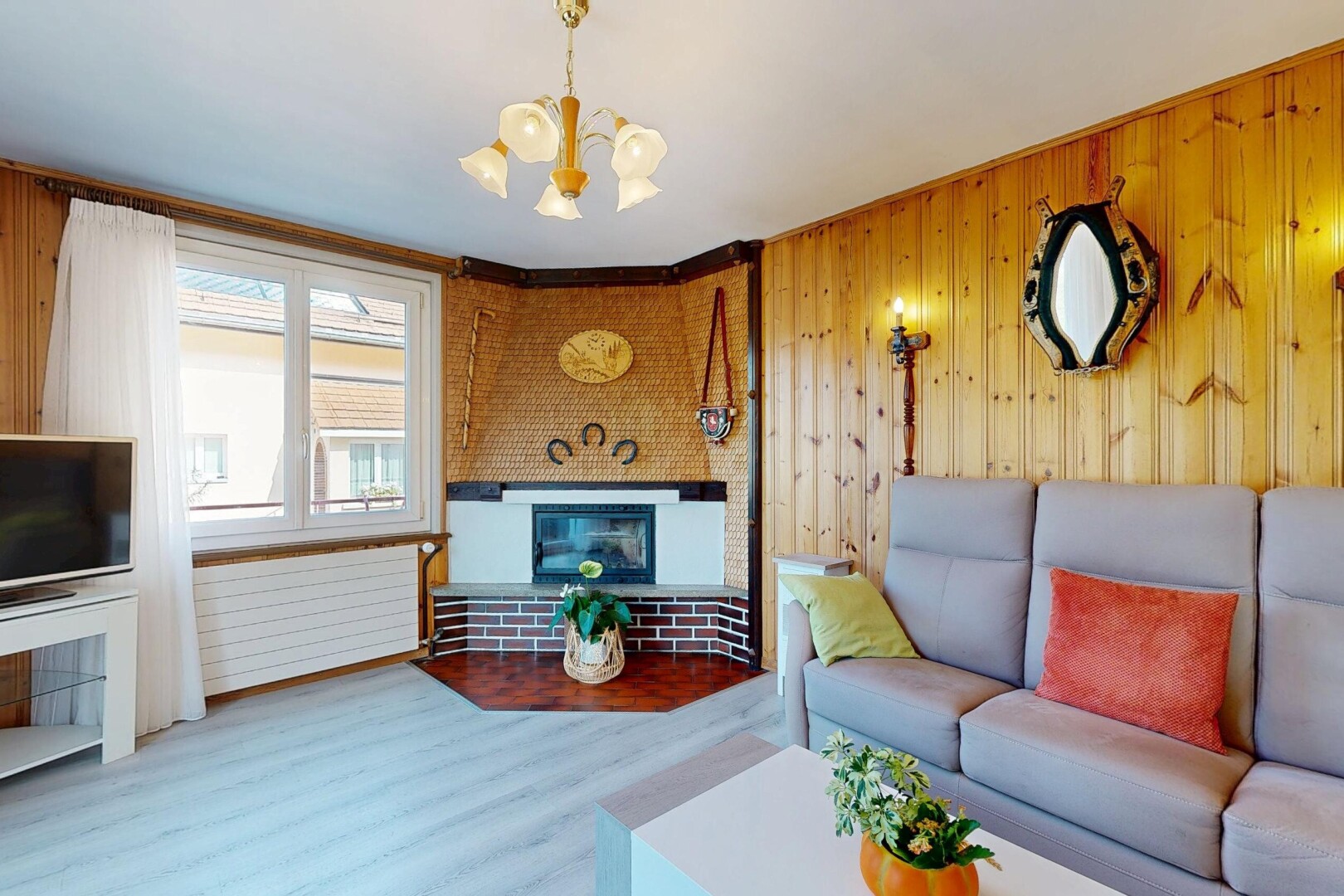 salon avec télévision, dated wood wall, cheminée, wood finish floor, et sol en finition bois