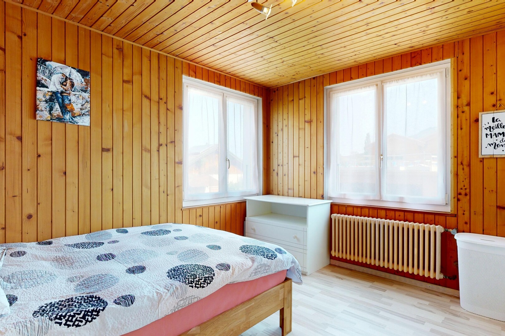 chambre avec radiateur, lumière naturelle, wood wall, mur en bois, et wood finish floor