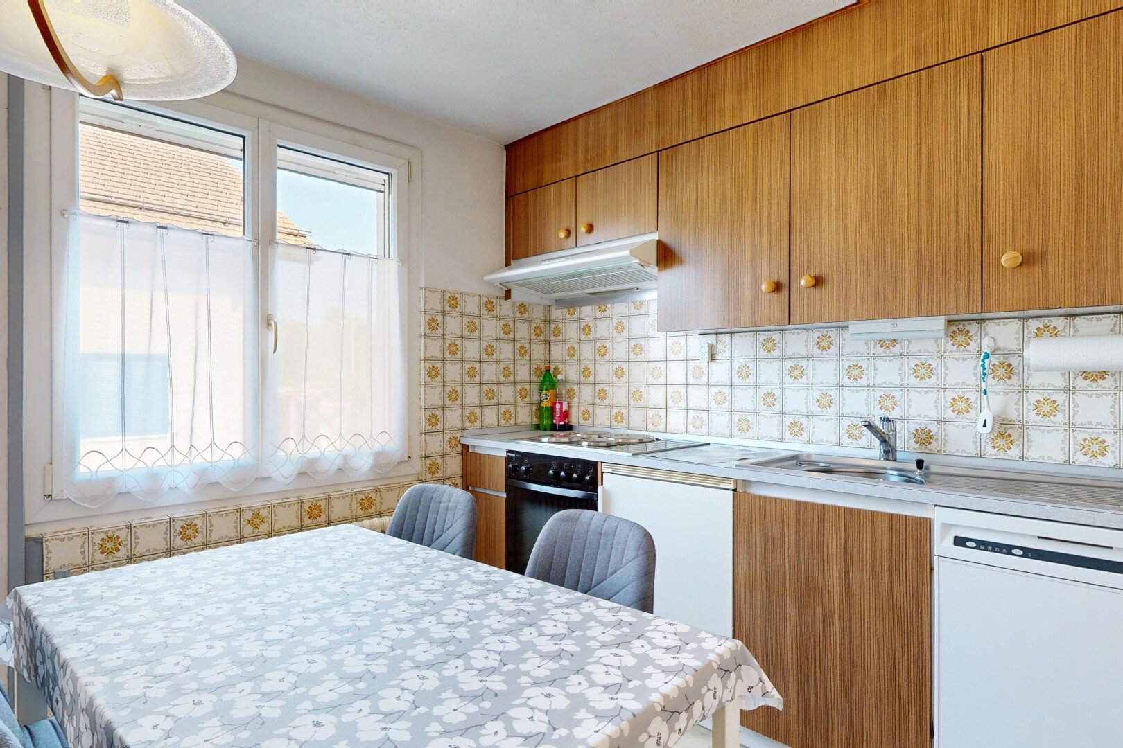 cuisine avec medium brown cabinets, armoires marron moyen, lave-vaisselle, hotte, et light countertops