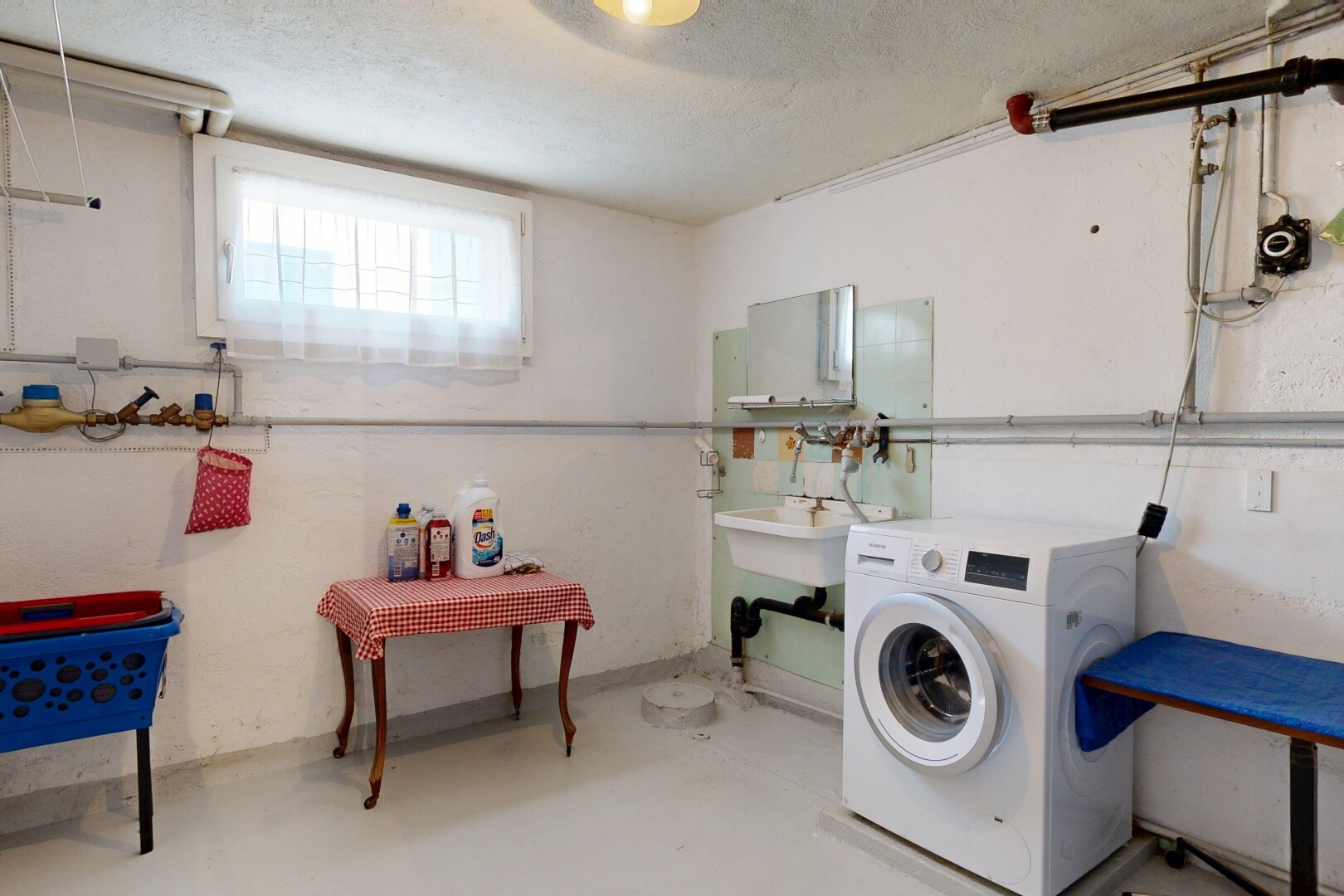 buanderie avec lave-linge et sèche-linge, lumière naturelle, sous-sol, inside property, et sol en béton