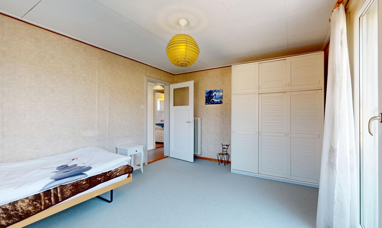 chambre avec placard, moquette, carpet, éclairage suspendu, et manufactured wall