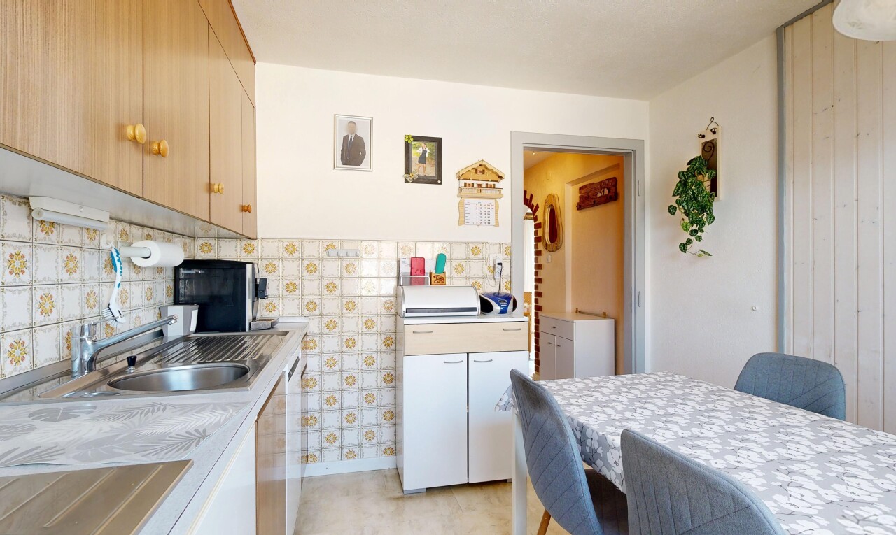 cuisine avec cloison sèche, drywall, light floor, light countertops, et plans de travail