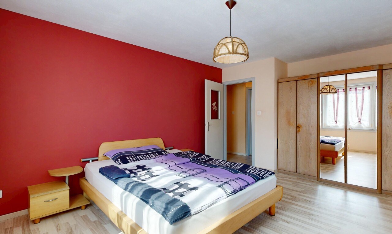 chambre avec cloison sèche, drywall, lumière naturelle, sol en finition bois, et wood finish floor