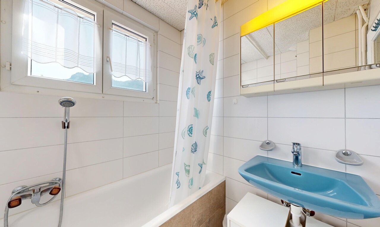 salle de bains avec tile wall, mur en carrelage, douche-bain combinés, évier, et salle de bain complète