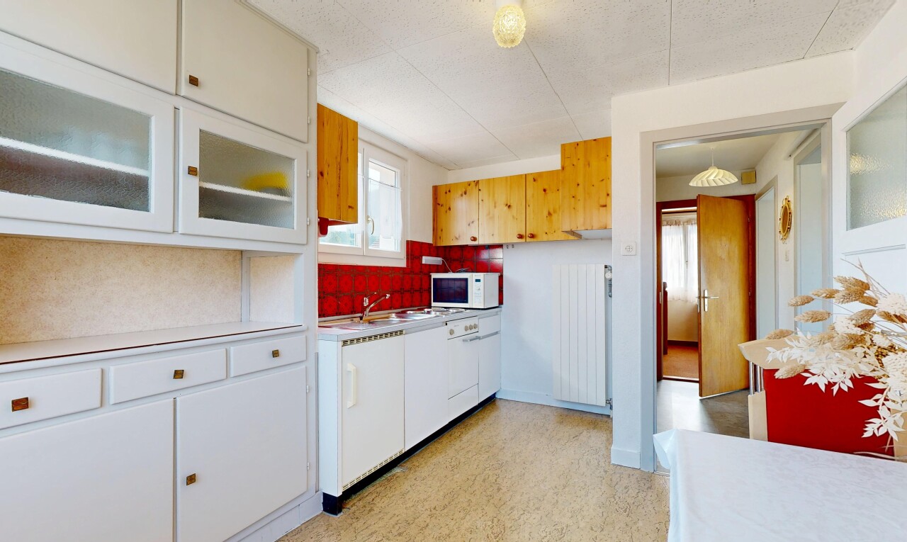 cuisine avec light countertops, plans de travail, light floor, radiateur, et white cabinets