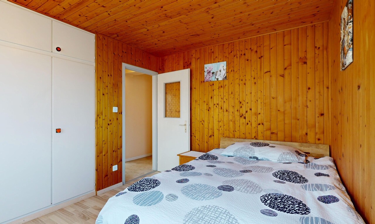 chambre avec sol en finition bois, wood finish floor, plafond en bois, wood ceiling, et placard