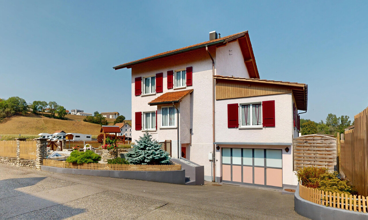 façade avec garage intégré, clôture, property visible, day time, et bardage en stuc