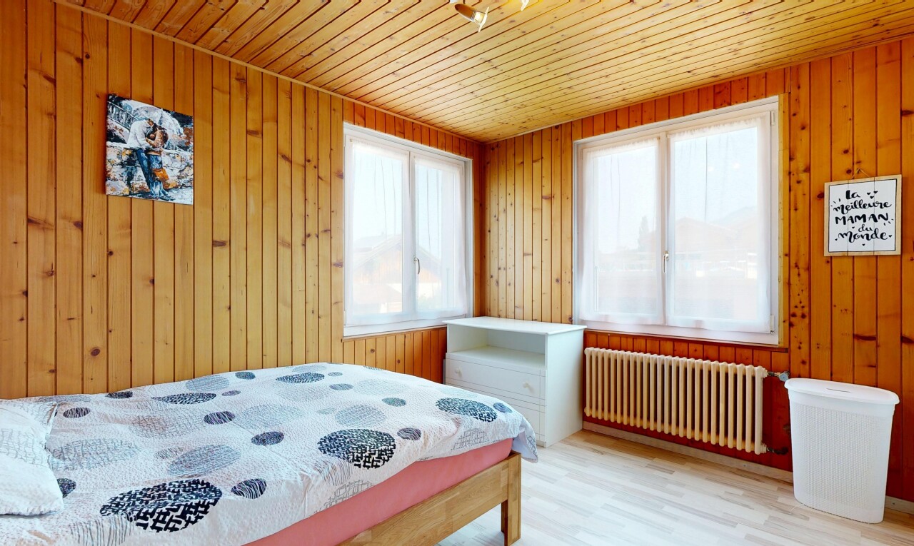 chambre avec radiateur, lumière naturelle, wood wall, mur en bois, et wood finish floor