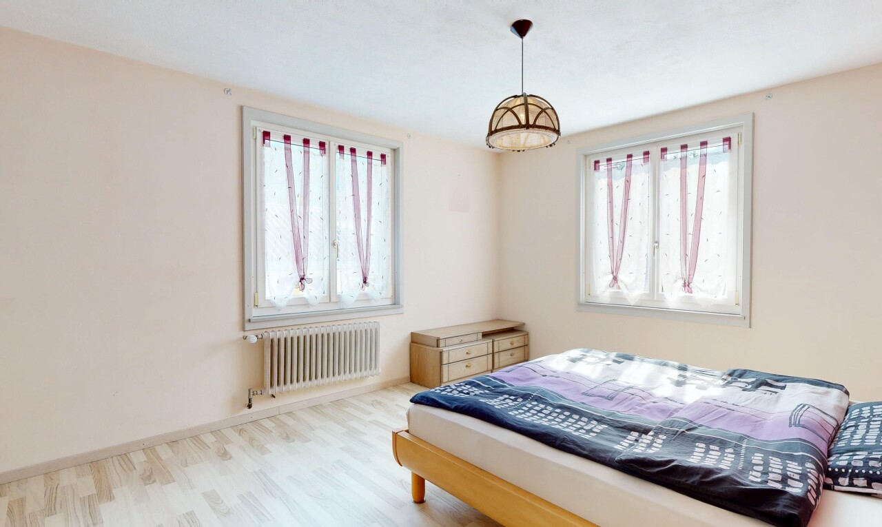 chambre avec radiateur, cloison sèche, drywall, lumière naturelle, et sol en finition bois