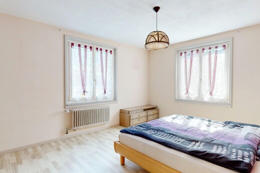 chambre avec radiateur, cloison sèche, drywall, lumière naturelle, et sol en finition bois